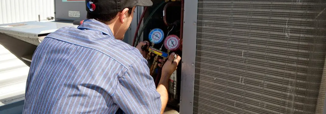 HVAC technician servicing a condenser unit in Livermore